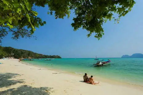 newlywed sit together on the white sand beach of Phi Phi island
